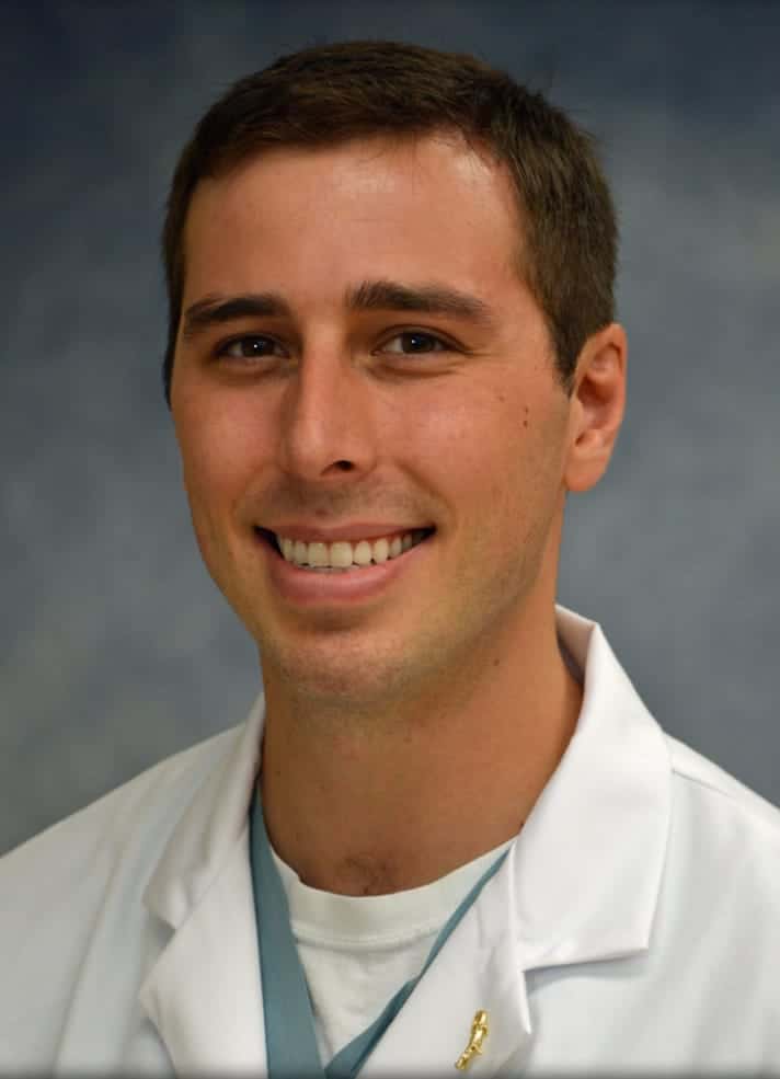 Smiling male doctor in a white lab coat.
